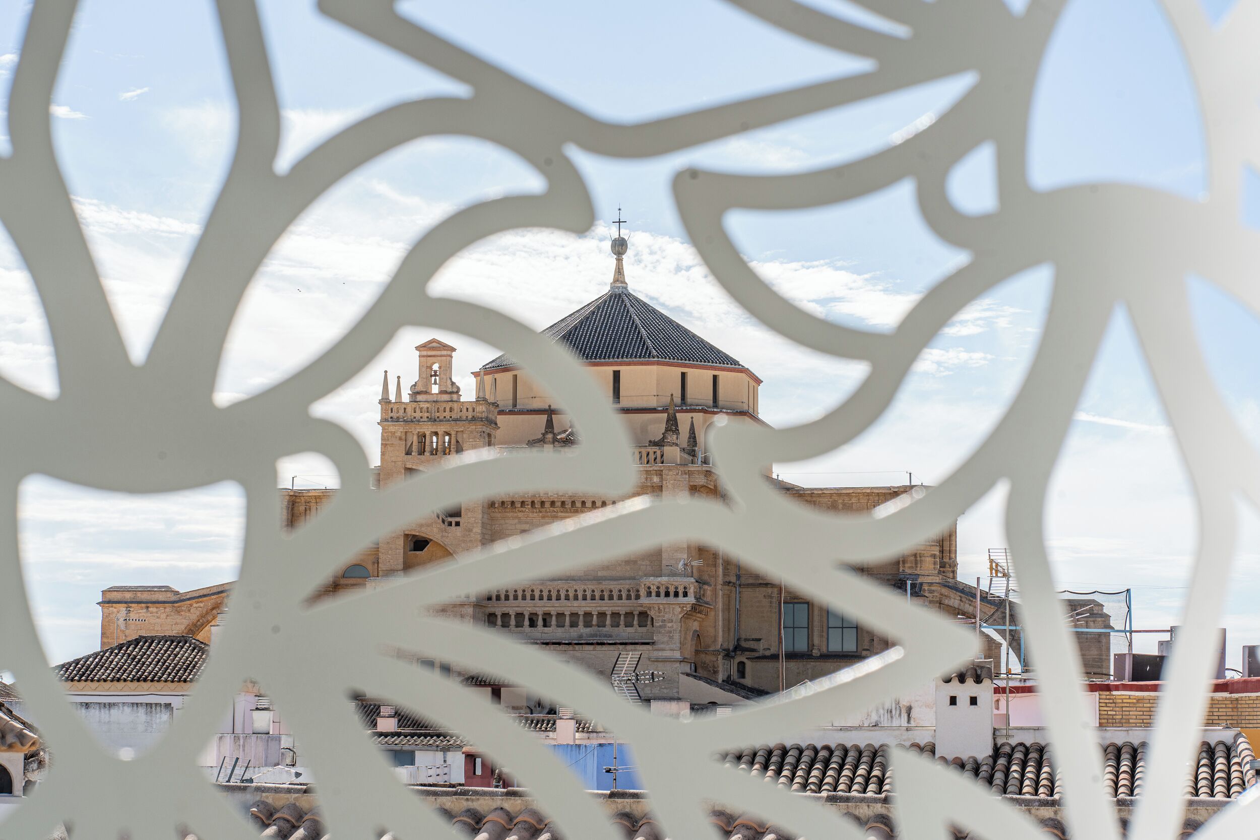 Vista de un edificio histórico con cúpula y varias torres, parcialmente oculto por una estructura blanca decorativa.