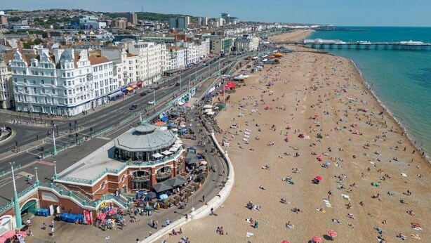 A coastal cityscape with a wide beach, a promenade, and a distinctive building with a dome. - Brighton Apartment Near Beach| Walk Everywhere (Brighton and Hove)