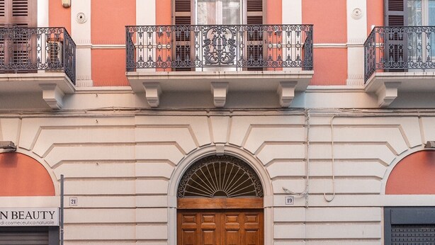 A building with a classic architectural style, featuring a central entrance with a large wooden door, flanked by two windows with shutters. - Cozy studio apartment in the center of Bari, renovated and tastefully furnished (Bari)