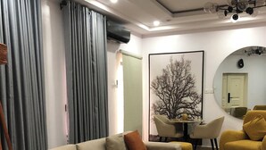 A modern living room with a beige sofa, a round coffee table, and a dining area with a table and chairs. - Spacious 3-bedroom apartment with AC, WiFi in fabulous Ikeja (Ikeja)