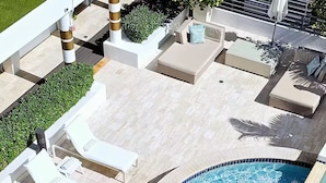 A pool area with lounge chairs and a hot tub. - Beach View at 101 Ocean Drive, SoFi in Miami Beach (Miami Beach)