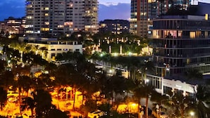 A cityscape at dusk with high-rise buildings, palm trees, and illuminated streets. - Beach View at 101 Ocean Drive, SoFi in Miami Beach (Miami Beach)