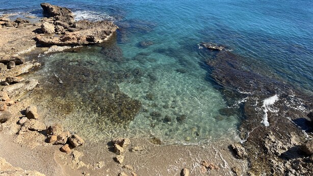 Un rivage rocheux, avec une eau claire et une vue sur la mer.
