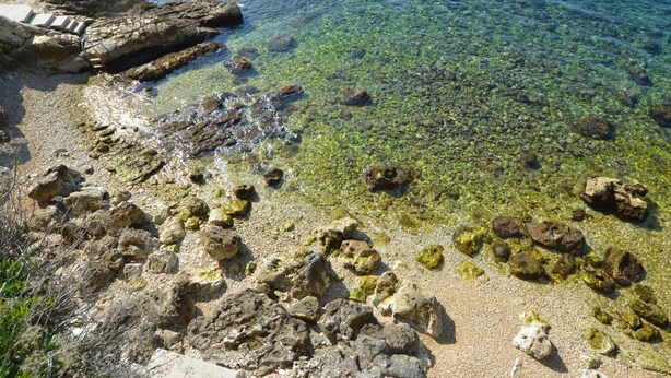 A rocky shoreline with clear water and a wooden structure. - Trendy and Chic Rovinj Downtown Apartments (Rovinj)