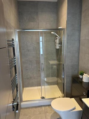 A modern bathroom with a glass-enclosed shower, a toilet, and a sink with a countertop. - Harrington Street Liverpool  (Liverpool)