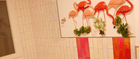 A bathroom with a bathtub, toilet, and bidet. There is a wall-mounted mirror above the toilet.