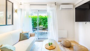 Una sala de estar moderna con un sofá, una mesa de centro y un televisor montado en la pared.