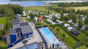 En campingplads med autocampere og en swimmingpool.