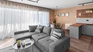 Een moderne woonkamer met een grijze hoekbank, een ronde salontafel en een eethoek met een kleine keuken.