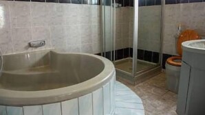 A bathroom with a bathtub, toilet, and shower. - THE HAVEN GUEST HOUSE THEMBELIHLE  (Mbabane)