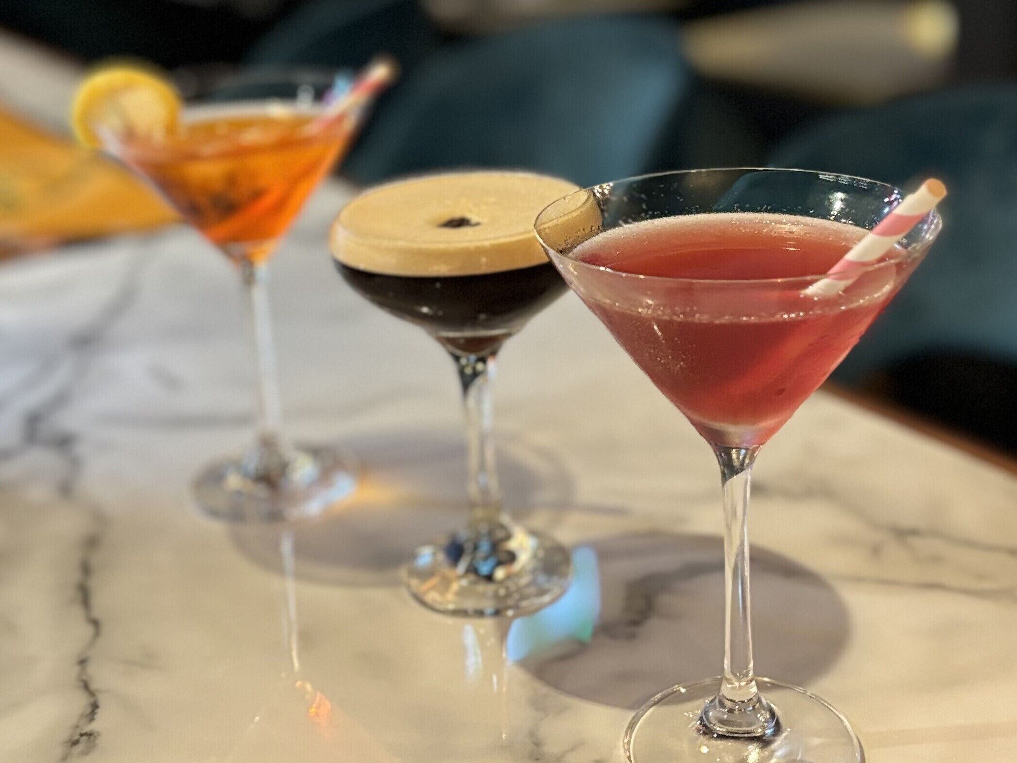 Three cocktails on a marble surface.