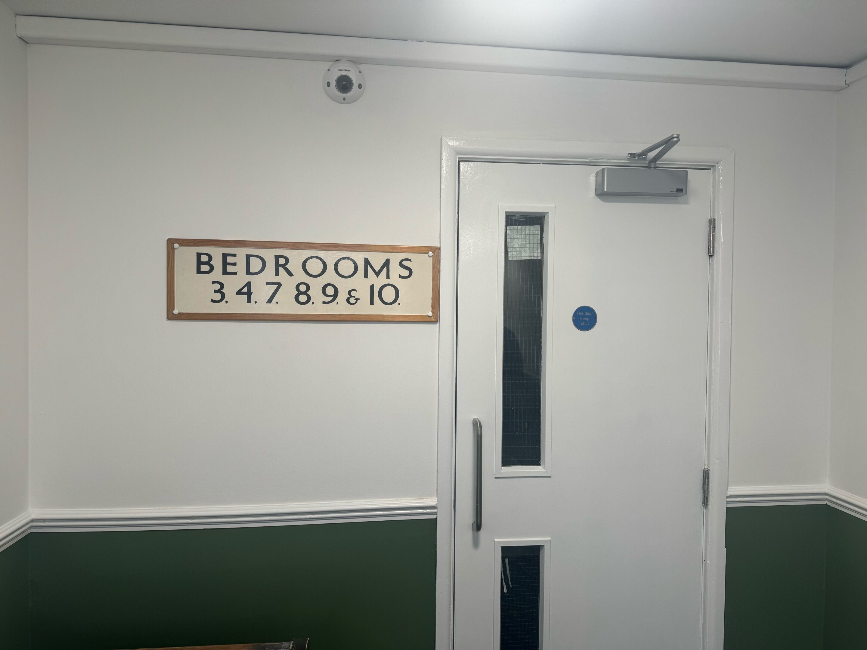 A door with a sign above it indicating the rooms 34789 & 10.