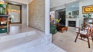 A spacious living area with a fireplace, a staircase, and a view into another room.