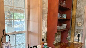 Una cucina con un lavandino bianco, un piano di lavoro in legno e un lampadario.