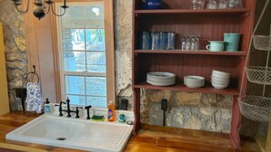 Una cucina con lavello, rubinetto e diversi piatti e utensili.
