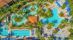 An aerial view of a resort with multiple swimming pools, palm trees, and sun loungers. - Newly Updated Luxury Condo at Naples Bay Resort - Pools, Spa, Lazy River & More! (Naples)