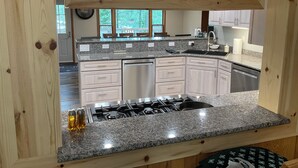 Una cocina con encimeras de granito, electrodomésticos de acero inoxidable y armarios de madera.