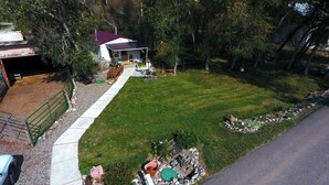 A residential property with a well-maintained lawn, a covered patio, and a garage.