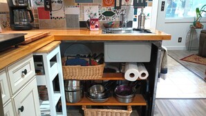 A compact kitchen with a coffee maker, a sink, and various kitchen utensils.