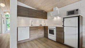 A modern kitchen with wooden cabinets, a built-in oven, a microwave, and a refrigerator.
