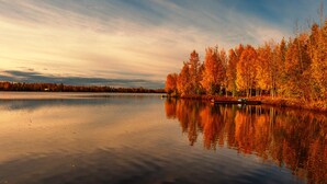 A calm lake with autumn-colored trees reflecting on the water. - Cozy lakefront cabin on Big Beaver Lake (Big Lake)