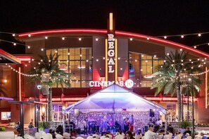 A building with a marquee sign reading 'REGAL CINCINNATI' and a stage with musicians performing.