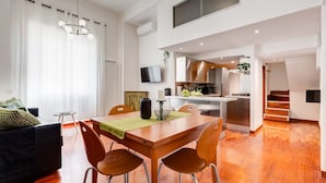 A modern apartment with a dining area, kitchen, and living space.