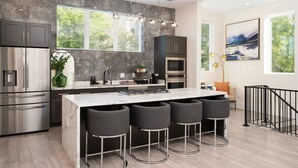 A modern kitchen with a marble island, stainless steel appliances, and a large window providing natural light. - Designer Luxury for 10•Rooftop Deck•Rice Military (HOUSTON)