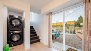 A laundry area with two washing machines, a staircase leading to an outdoor patio with a grill and seating. - Bryce Zion Vacation (Kane County)