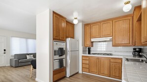 Una cocina moderna con armarios de madera, un refrigerador de acero inoxidable y un salpicadero de azulejos.