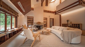 A spacious living room with a fireplace, a large sofa, and a wooden rocking chair. - ZhangJiaJieFuXiErYi (Zhangjiajie)