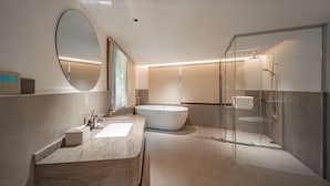 A modern bathroom with a freestanding bathtub, a glass-enclosed shower, and a vanity with a large mirror. - ZhangJiaJieFuXiErYi (Zhangjiajie)