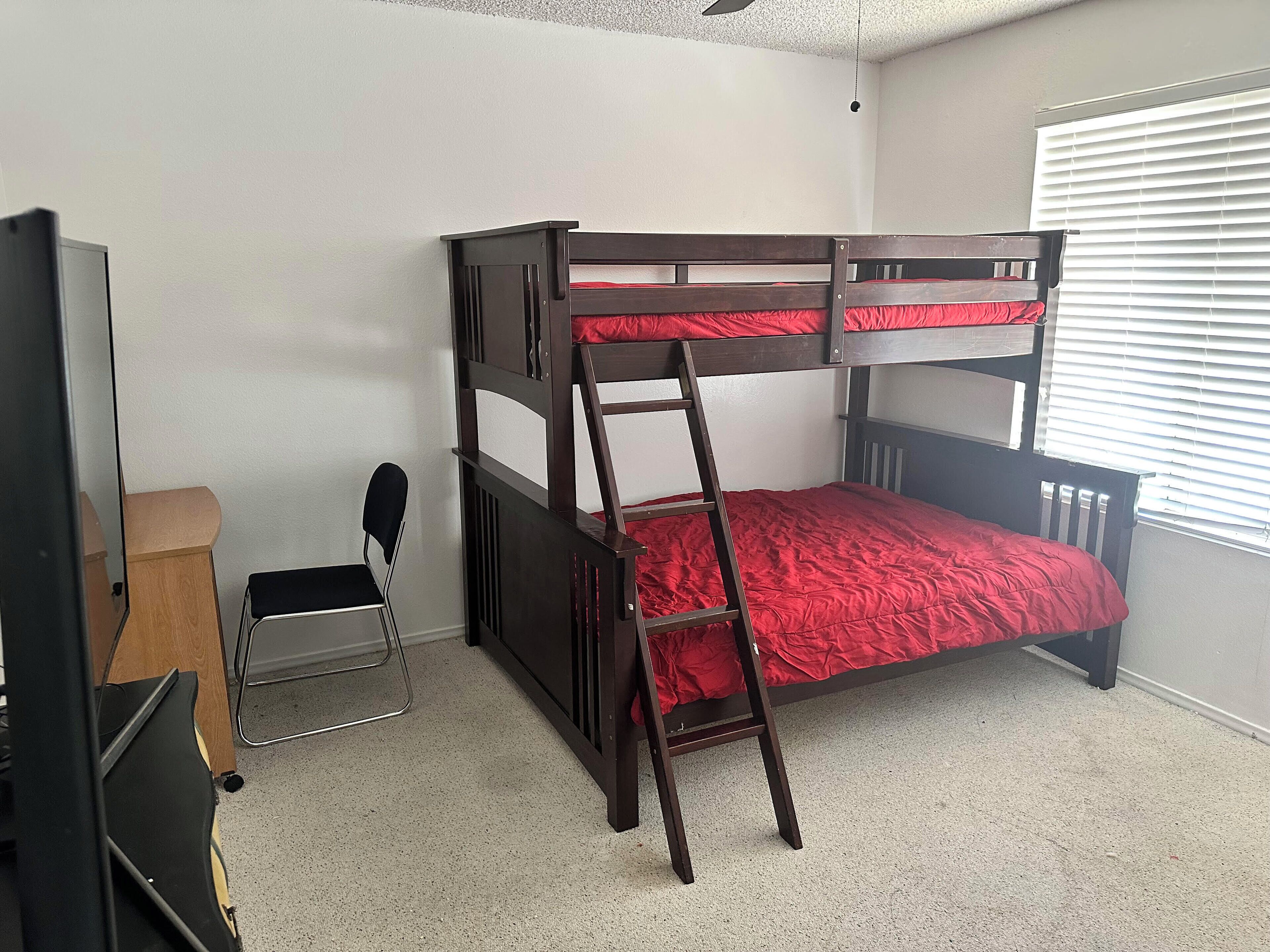Habitación con literas, escritorio y una silla.