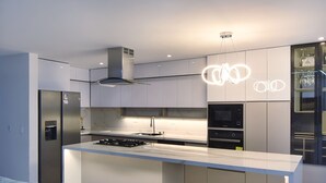 A modern kitchen with a central island, built-in appliances, and a sleek design. - Valymar Inn (Cali)