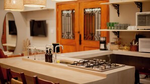 A modern kitchen with a central island, pendant lights, wooden cabinets, and a microwave. - YELLOW HOUSE - (House for up to 8 people.) (Solar dos Lagos II Bonito)