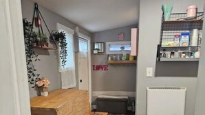 Une cuisine compacte avec une table en bois, un banc et une étagère contenant des ustensiles de cuisine.