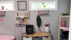 Une chambre à coucher comprenant un lit, une commode, un petit bureau et une fenêtre donnant sur un paysage verdoyant.