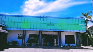 A building with a green facade and a sign that reads "Hotel". - INDRA DJAYA HOTEL (Megamendung)