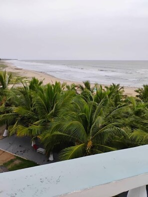 A beach view with palm trees and a sandy shore. - Gye Nyame Grand Beach Resort (Winneba)