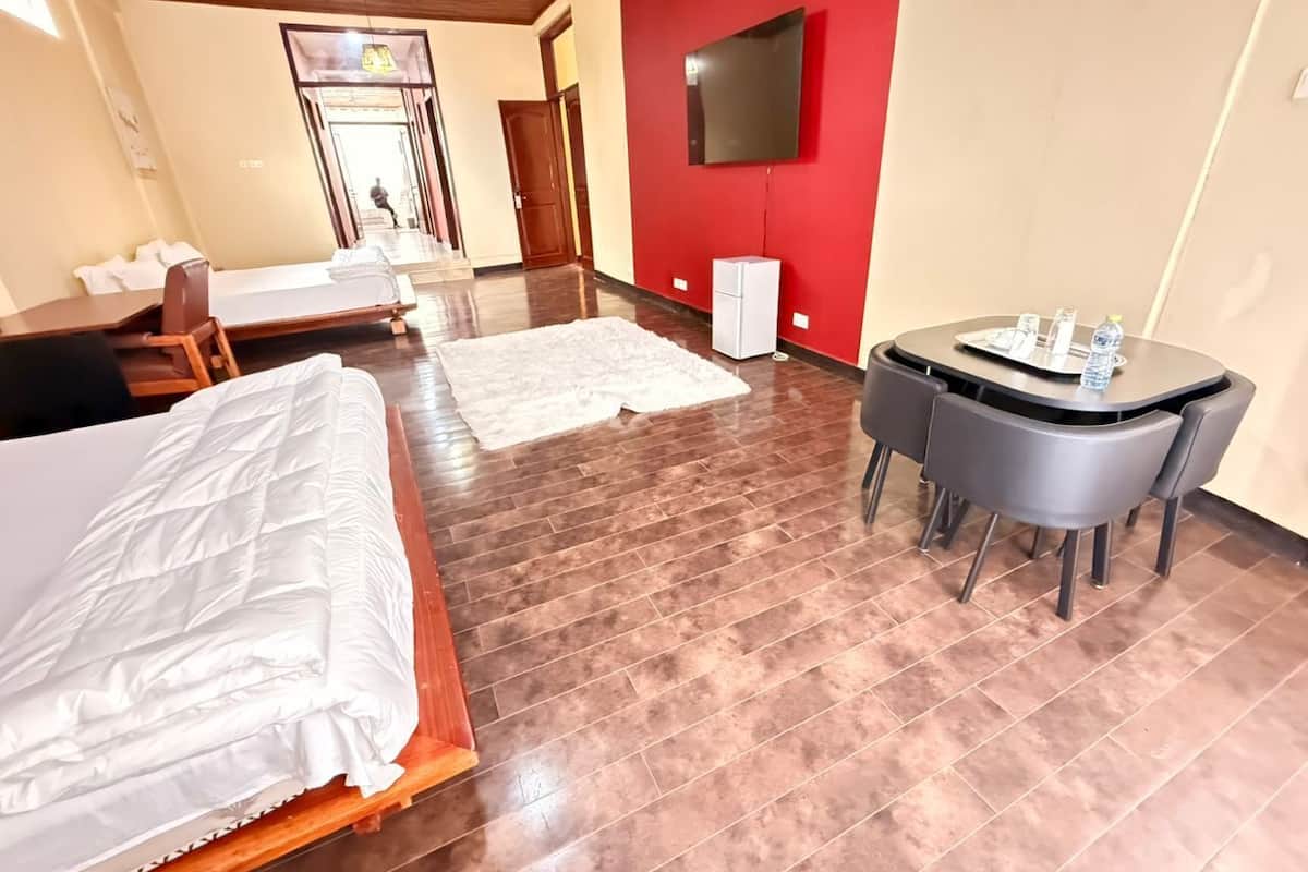 Ein Hotelzimmer mit Bett, Schreibtisch und Fernseher.