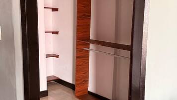 A hallway with a wooden accent wall, white walls, and a tiled floor.