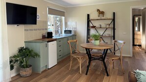 A modern kitchen with a built-in microwave, a ceiling fan, and a dining area with a round table and four chairs.