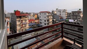 A balcony with a view of a cityscape, including various buildings and a clear sky. - Nishan Apartments and Home (Pokhara)