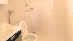 A bathroom with a toilet, sink, and shower. - Nishan Apartments and Home (Pokhara)