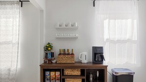 Una estación de café ordenada con una cafetera, tazas y diversos productos de café.