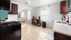 Una cocina moderna con estufa, lavamanos y comedor.