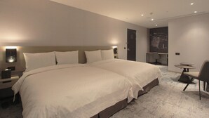 A hotel room with two large beds, a small desk, a chair, and a round table. - Tango INN Taipei Kaifong (Taipei)