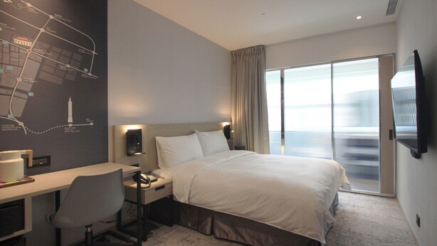 A hotel room with a bed, desk, chair, and a large window. - Tango INN Taipei Kaifong (Taipei)