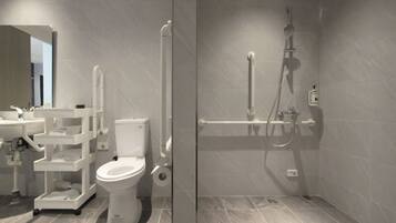 Un baño moderno con inodoro, lavamanos y zona de ducha.
