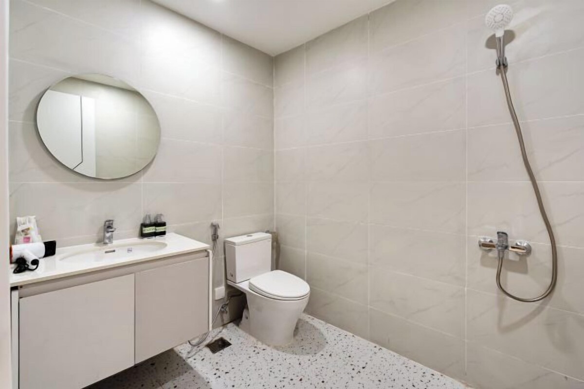 A modern bathroom with a toilet, sink, and shower.